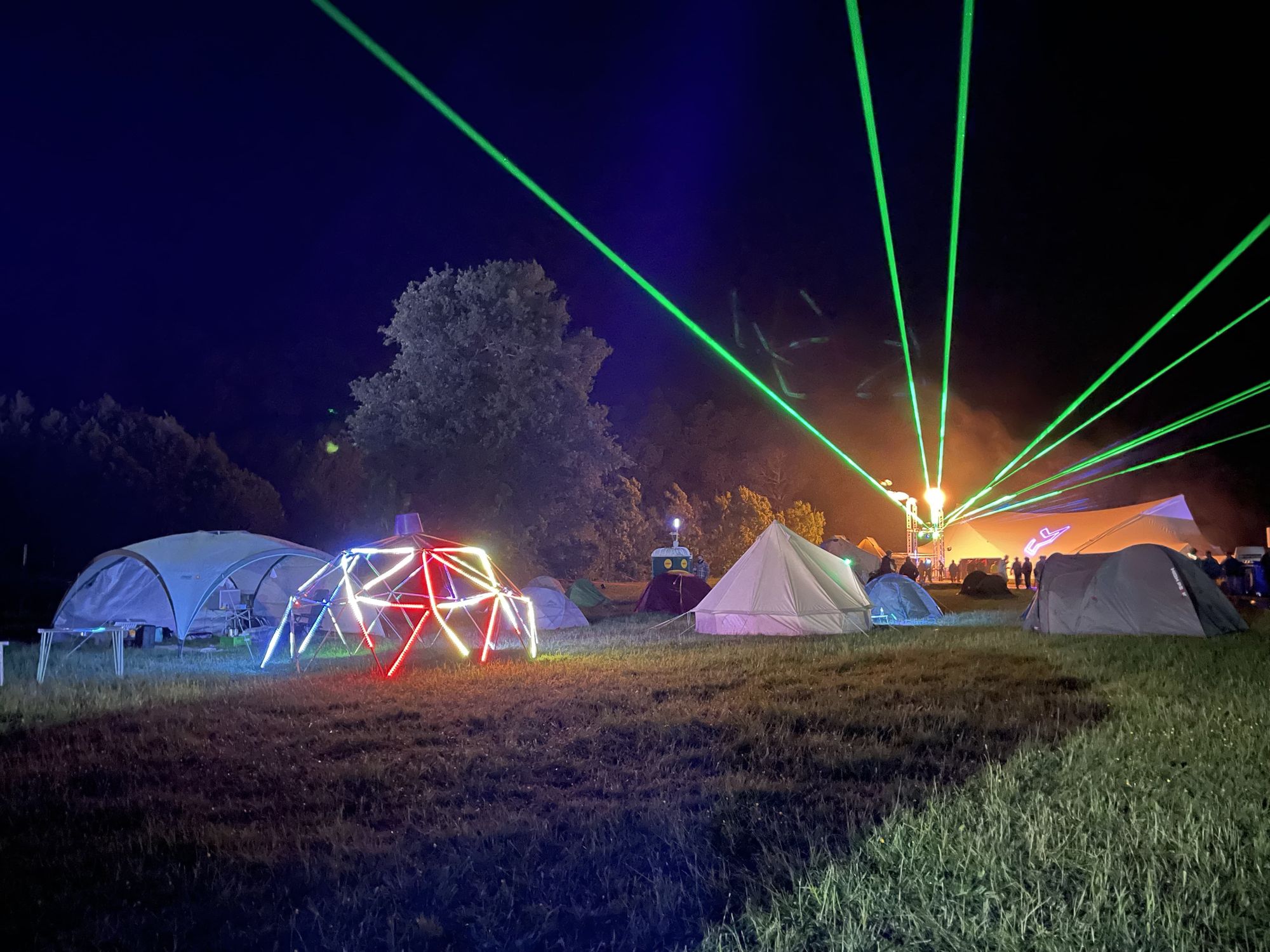 Camping site with tents surrounded by neon lights